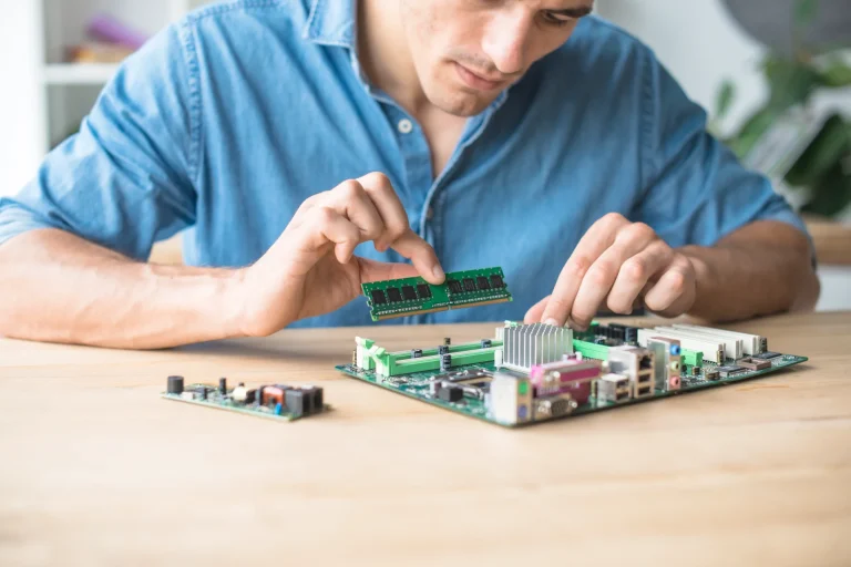 technician-inserting-ram-socket-computer-motherboard